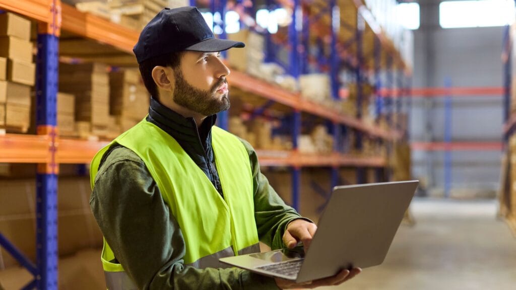 Contrôle du stock sur ordinateur en entrepôt logistique