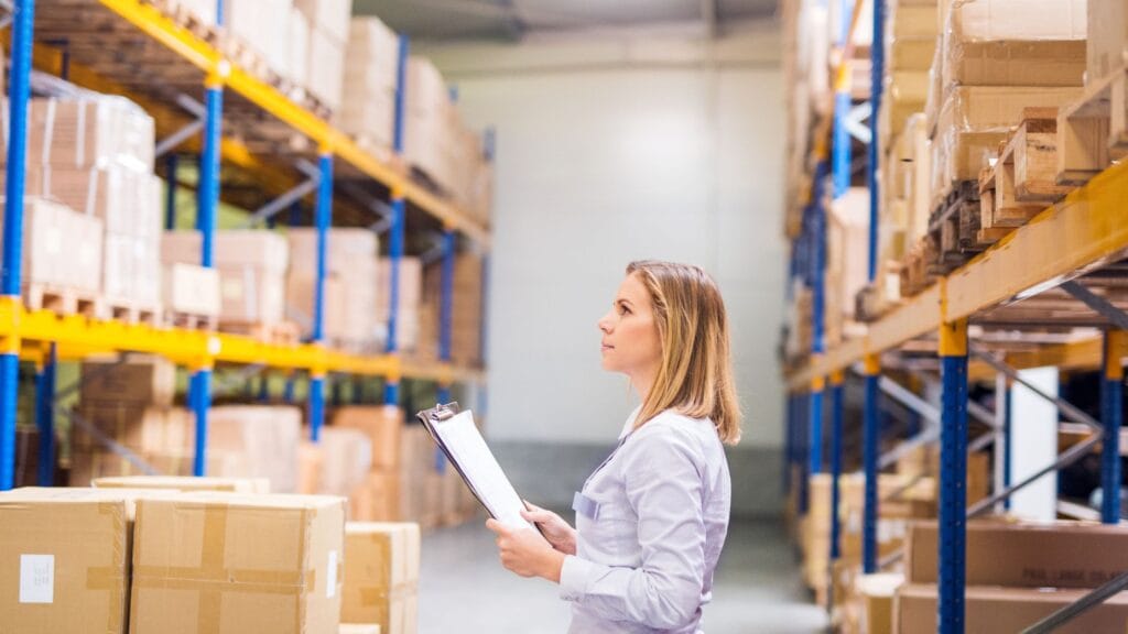 Femme réfléchissant dans un entrepot aux coûts logistique e-commerce